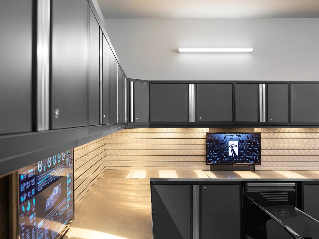 Modern garage with black cabinets and technology monitors