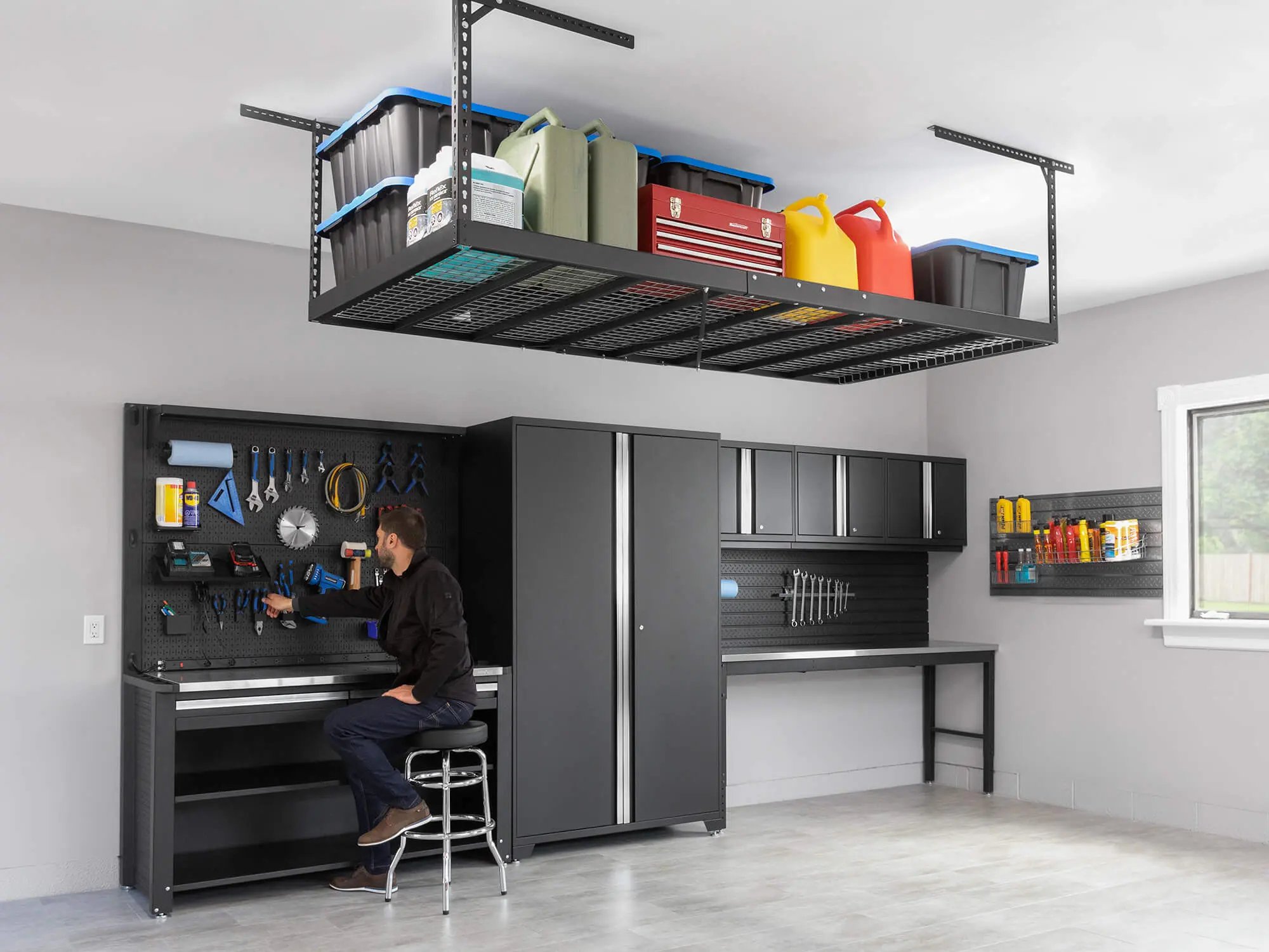 man sitting at cabinet storage with tools and ceiling mounted storage