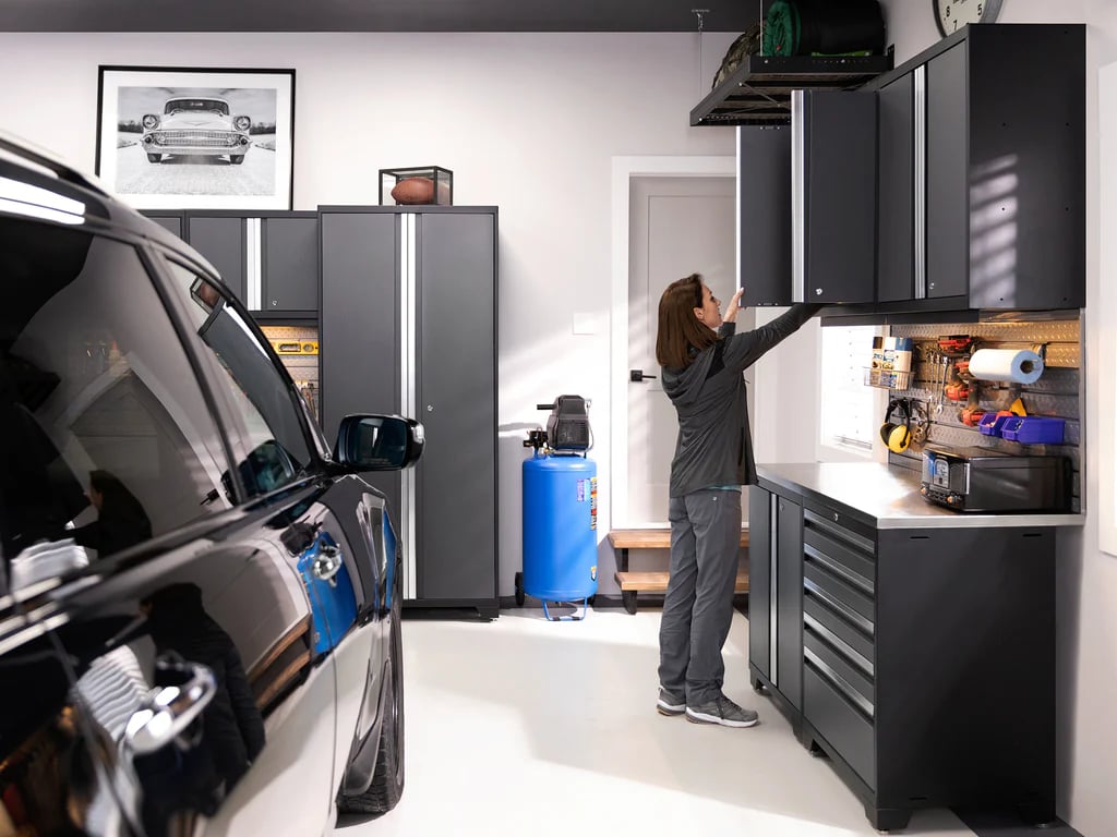 female putting away items in black NewAge cabinets in her garage